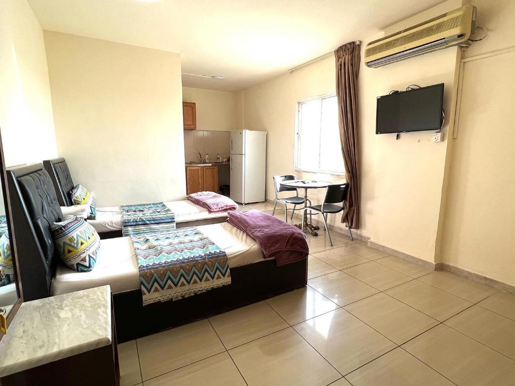 a hotel room with two beds and a television at Al Qatal Building in Al Qasţal