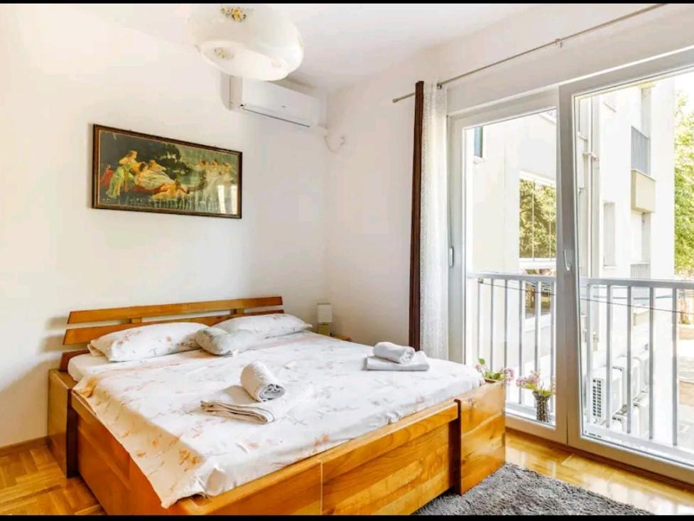 a bedroom with a bed and a large window at Apartman Borislava in Trebinje
