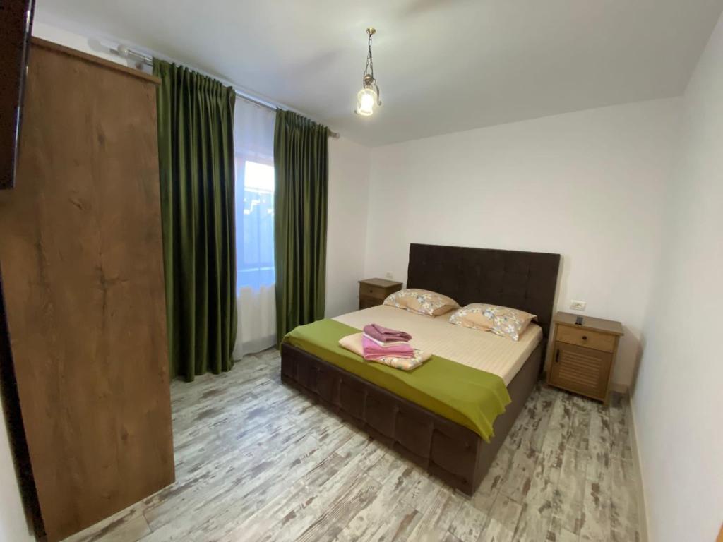 a bedroom with a bed and a window with green curtains at Casa Maria in 2 Mai