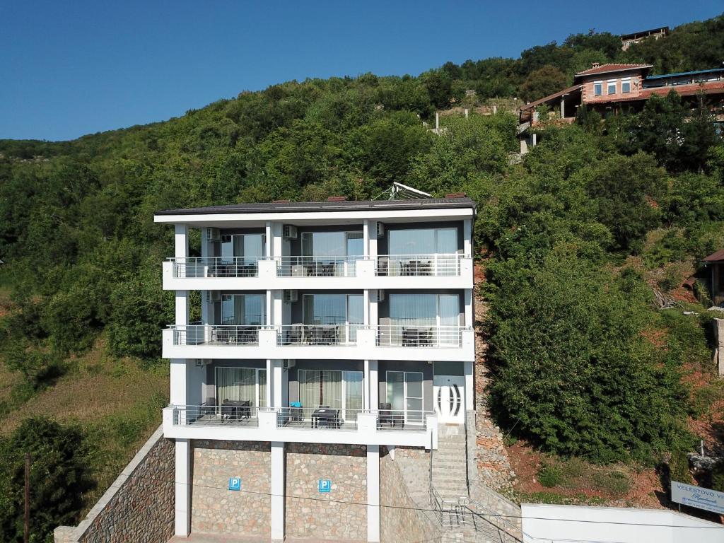 Velestovo View Apartments في أوخريد: مبنى على جانب تل