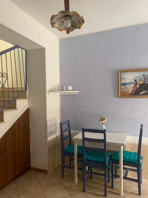 a dining room with a table and chairs and a staircase at Alice's Apartment in Castellammare del Golfo
