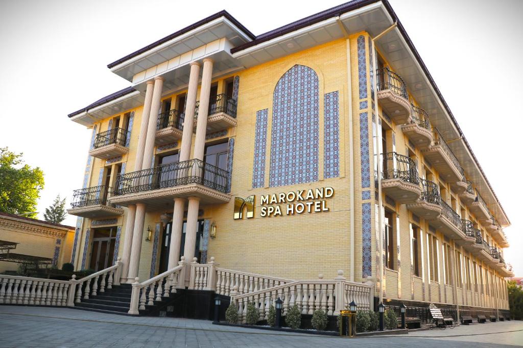 un grand bâtiment avec un panneau sur son côté dans l'établissement Marokand Spa Hotel, à Samarcande