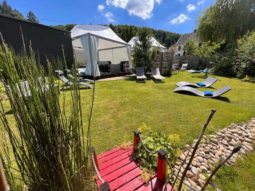 - un jardin avec un kiosque et des chaises dans la cour dans l'établissement Lodge spa privatif Sylvestre, séjour zen, à Meisenthal