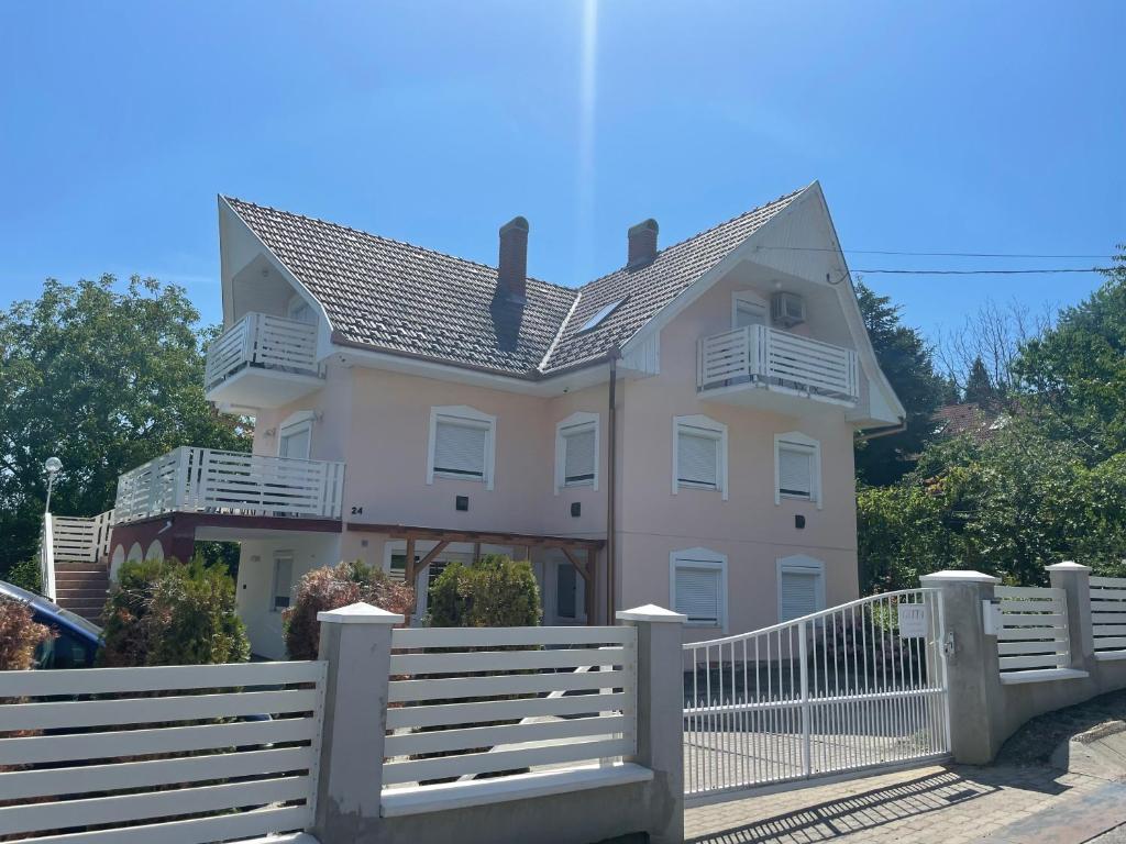 a house with a white fence in front of it at Gitta Apartmanház in Zalakaros