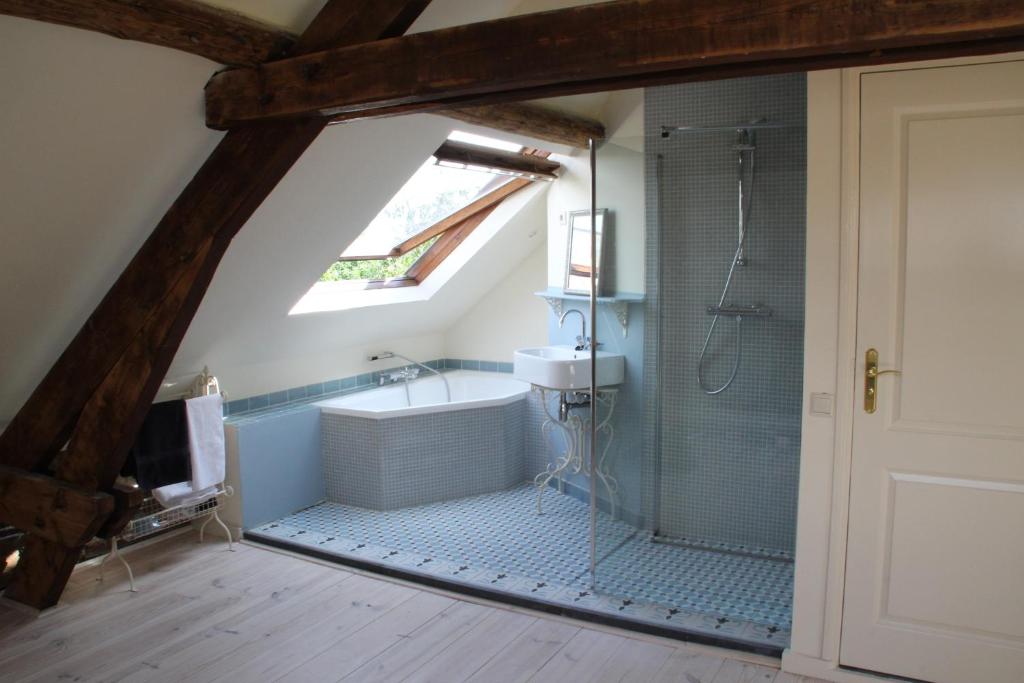 een badkamer op zolder met een douche en een wastafel bij Annelies'Place to B& B in Maastricht