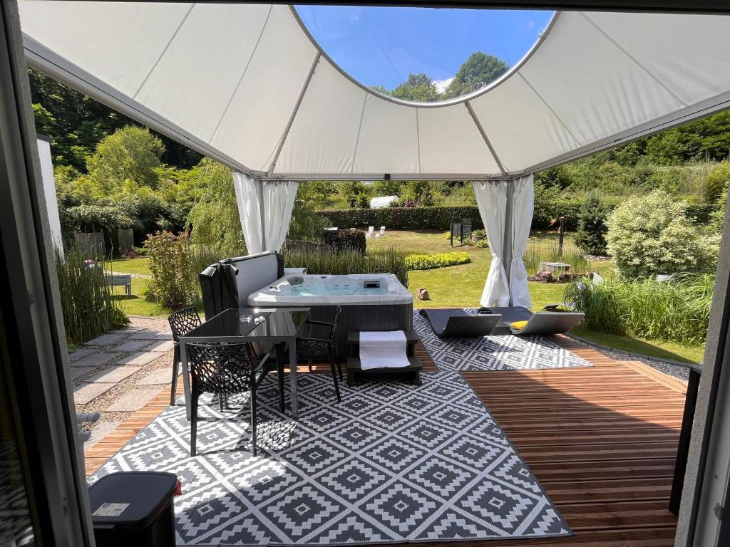 une terrasse avec une table et des chaises sous une tente dans l'établissement Lodge spa privatif Silex, séjour zen, à Meisenthal