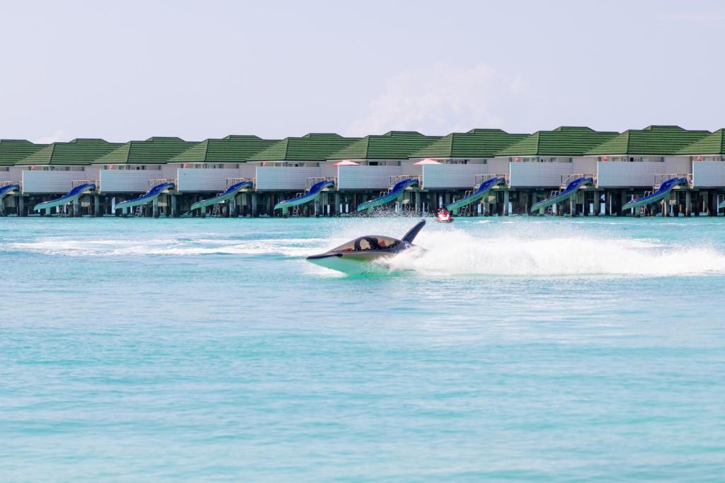 a jet ski in the water in front of a building at Siyam World Maldives - 24-Hour Premium All-inclusive with Free Transfer in Dhigurah