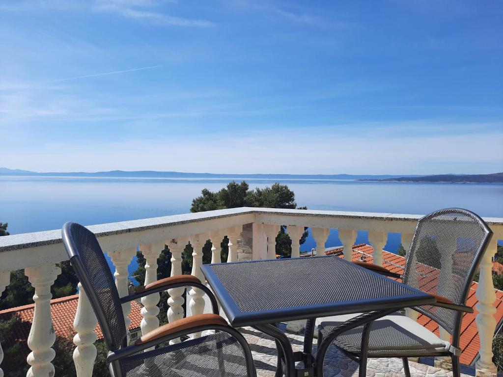 uma mesa e cadeiras numa varanda com vista para a água em Apartman Saric K&M em Baška Voda