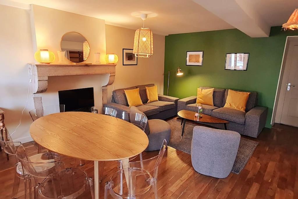 een woonkamer met een bank en een tafel bij Maison de charme - Au coeur de Puligny-Montrachet in Puligny-Montrachet