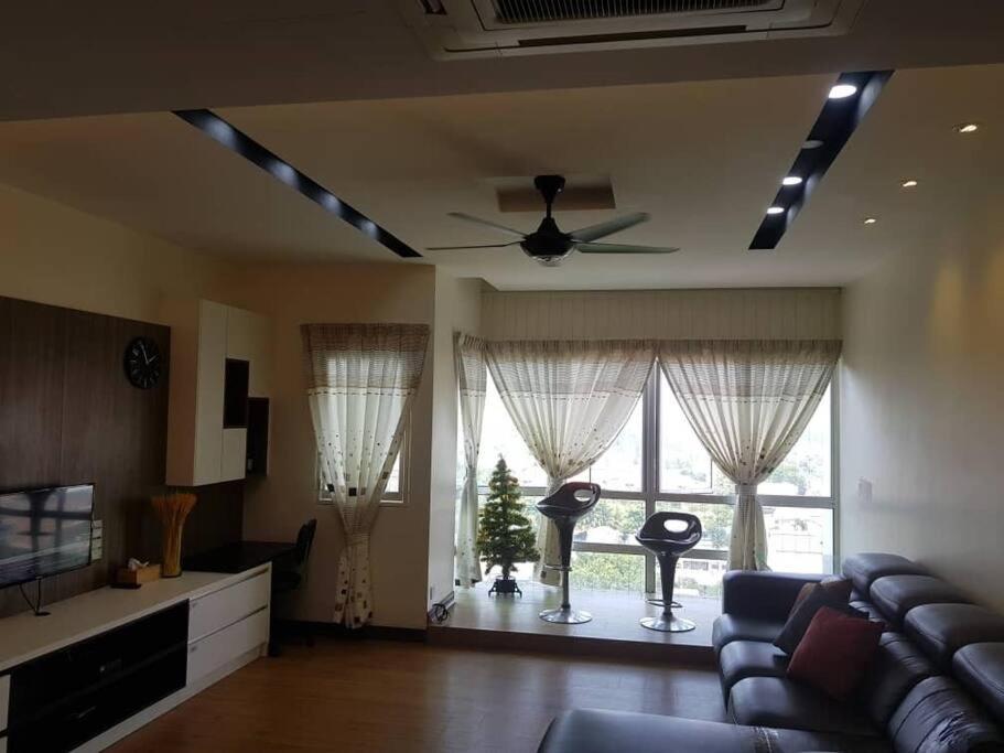 a living room with a couch and a ceiling fan at Best Sekinchan homestay in Sekinchan