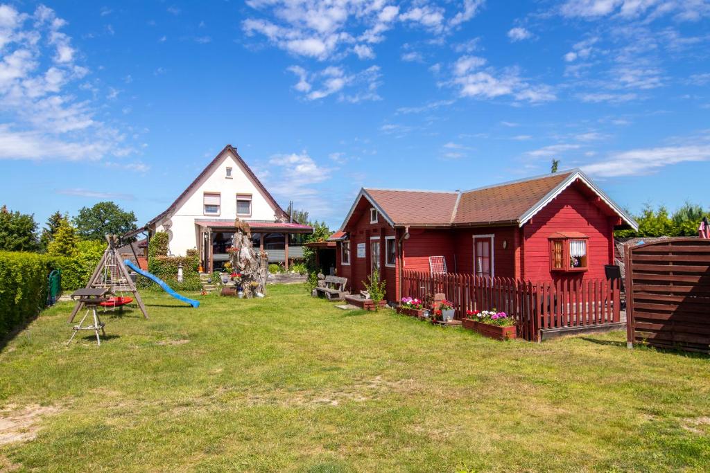 un patio con una casa y un parque infantil en Zur Sonne, en Freest