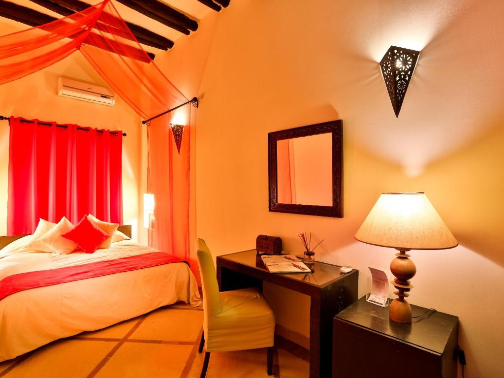 a bedroom with a bed and a desk with a lamp at Riad Casa Lalla in Marrakech