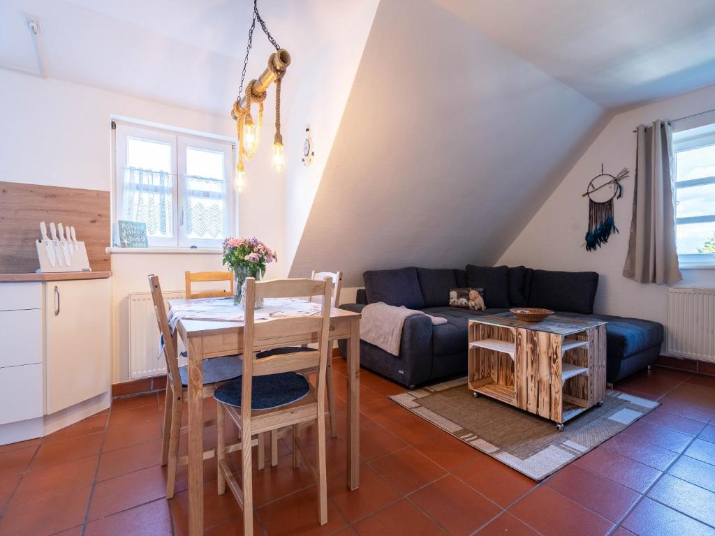 uma sala de estar com uma mesa e um sofá em Feriendorf Rugana - Komfort Appartement mit 1 Schlafzimmer B12 em Dranske