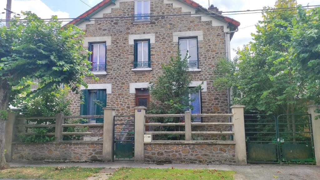 une vieille maison en briques avec une clôture devant elle dans l'établissement Chambres HABILIS, à Paray-Vieille-Poste