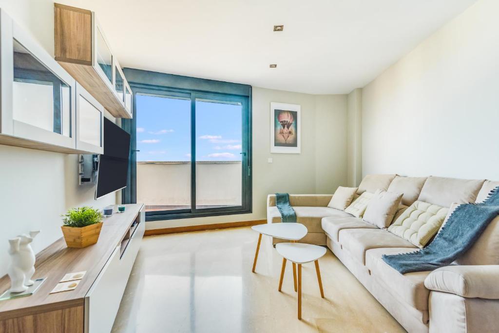een woonkamer met een bank en een tafel bij Home2Book Charming Urban Siete Palmas in Las Palmas de Gran Canaria
