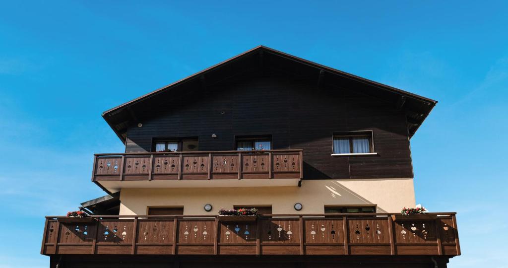 a black building with a balcony with flowers on it at Genzianella in Tarvisio