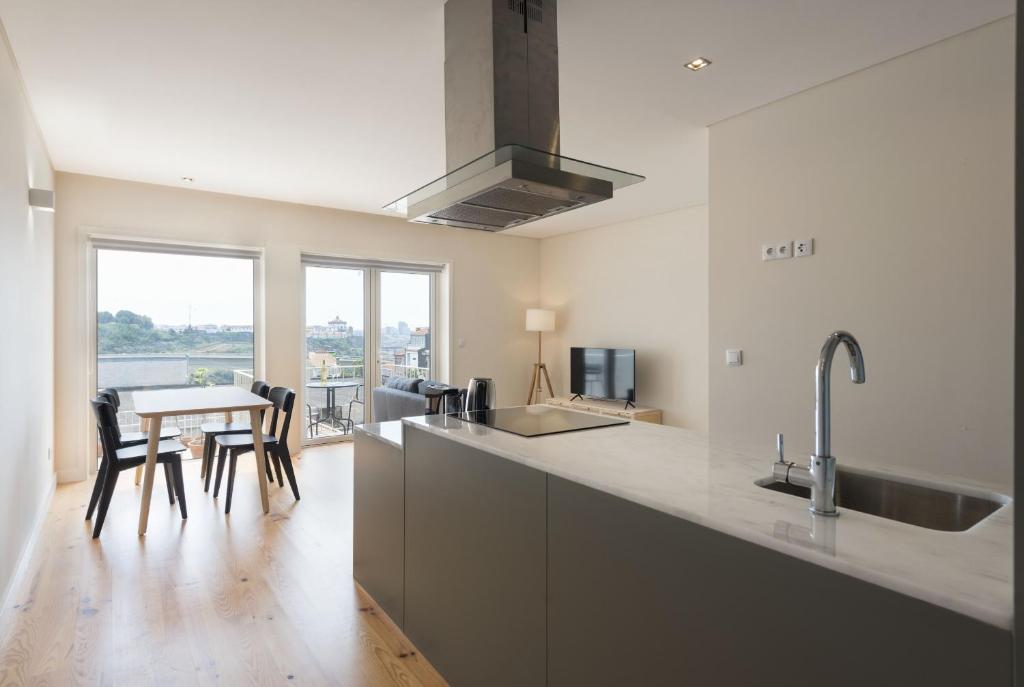 une cuisine avec un évier et une table avec des chaises dans l'établissement BmyGuest - Sao Vitor Balcony Apartment, à Porto