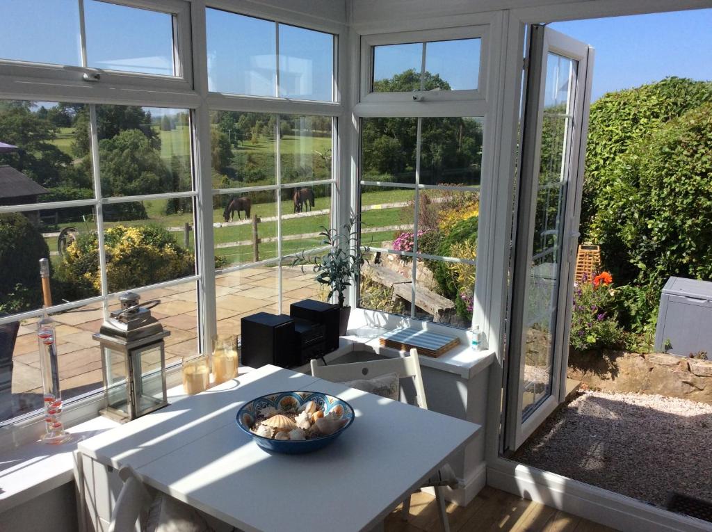 a room with a table with a bowl of food on it at Ty Bach, 1 bedroom home with hot tub and views in Bettws-yn-Rhôs