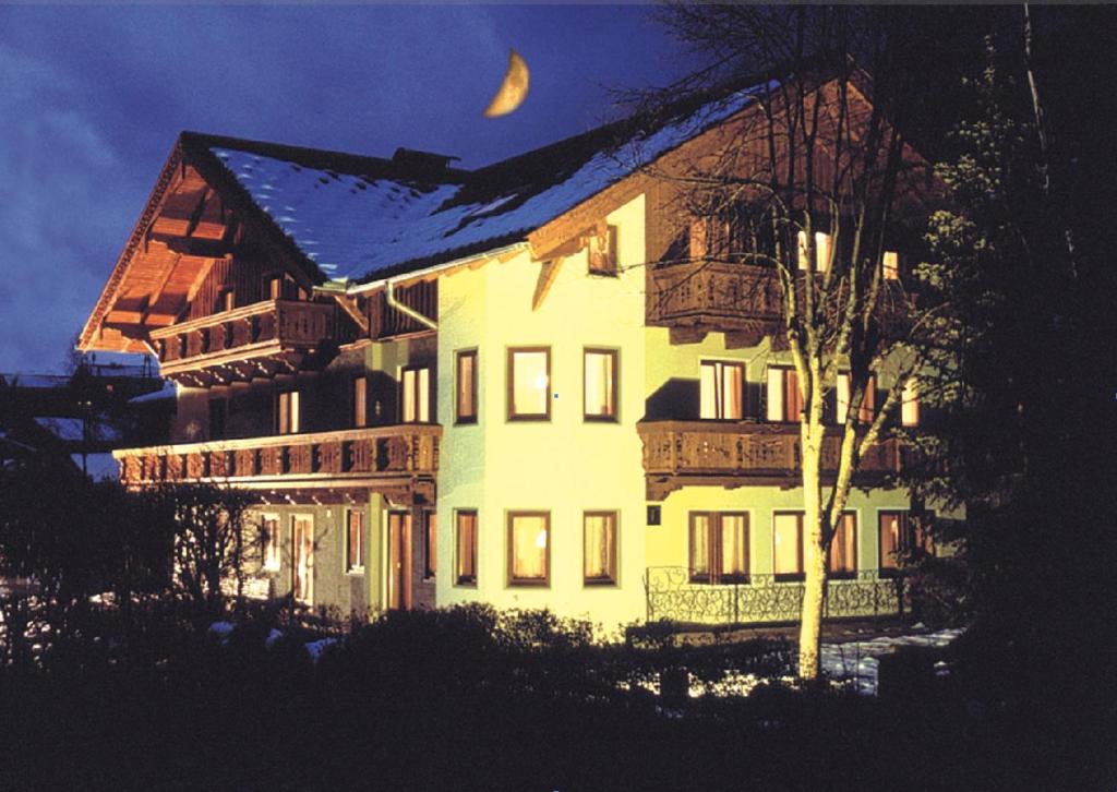 ein großes weißes Haus mit einem Mond am Himmel in der Unterkunft Sportpension Bergblick in Wagrain