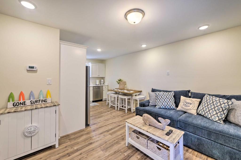a living room with a blue couch and a kitchen at Wildwood Condo with Pool Access - Walk to Beach in Wildwood