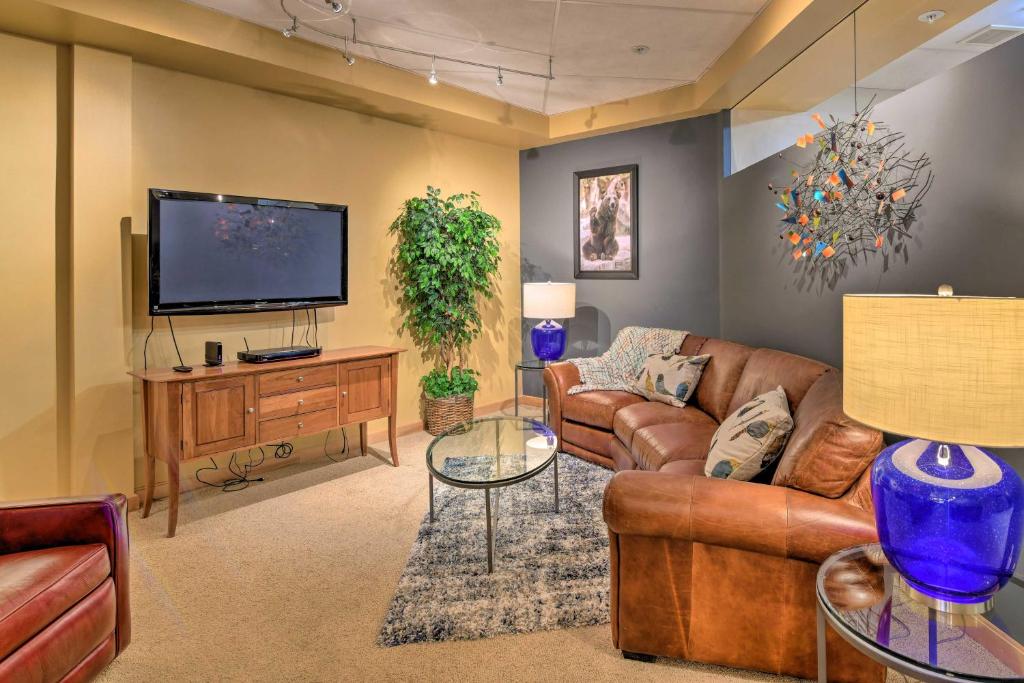 a living room with a couch and a tv at Idyllic Dtwn Anchorage Condo with Fireplace! in Anchorage