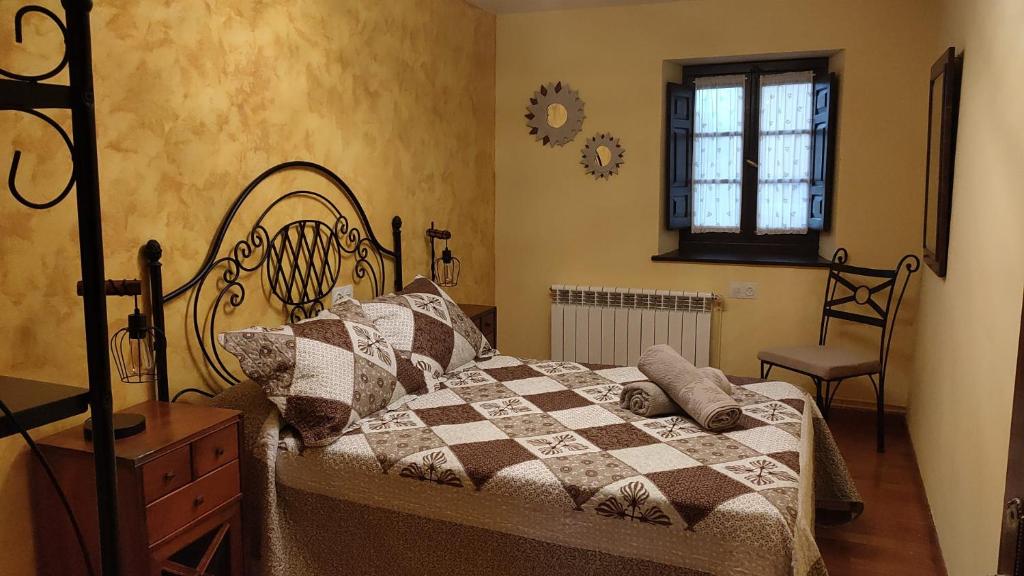 a bedroom with a bed and a chair and a window at Casa Joglar in Beceña