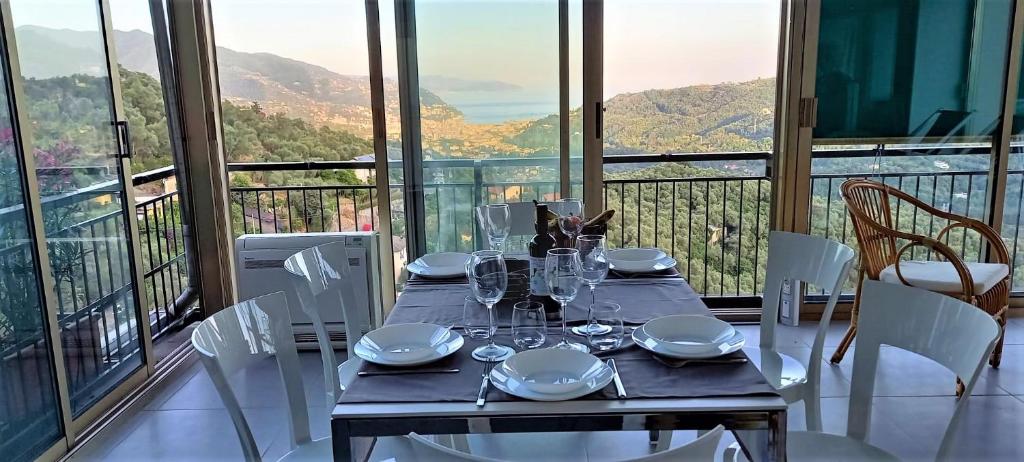 einen Esstisch mit weißen Stühlen und Bergblick in der Unterkunft La Terrazza sul Golfo in Rapallo