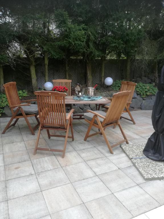 a patio with a table and three chairs at Im Vulkanland Fewo bis 6 Personen in Ettringen