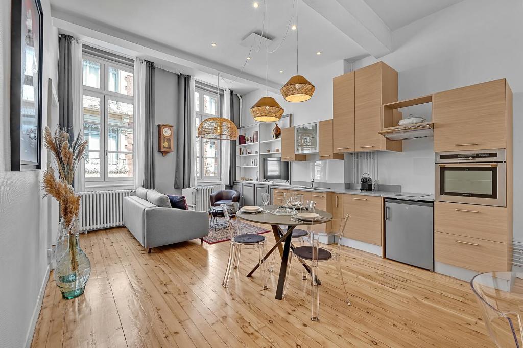 a kitchen and living room with a table and a couch at Le Salini in Toulouse