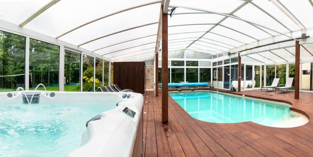 uma grande piscina com telhado de vidro em VILLA AVEC PISCINE PRIVEE em Auberville