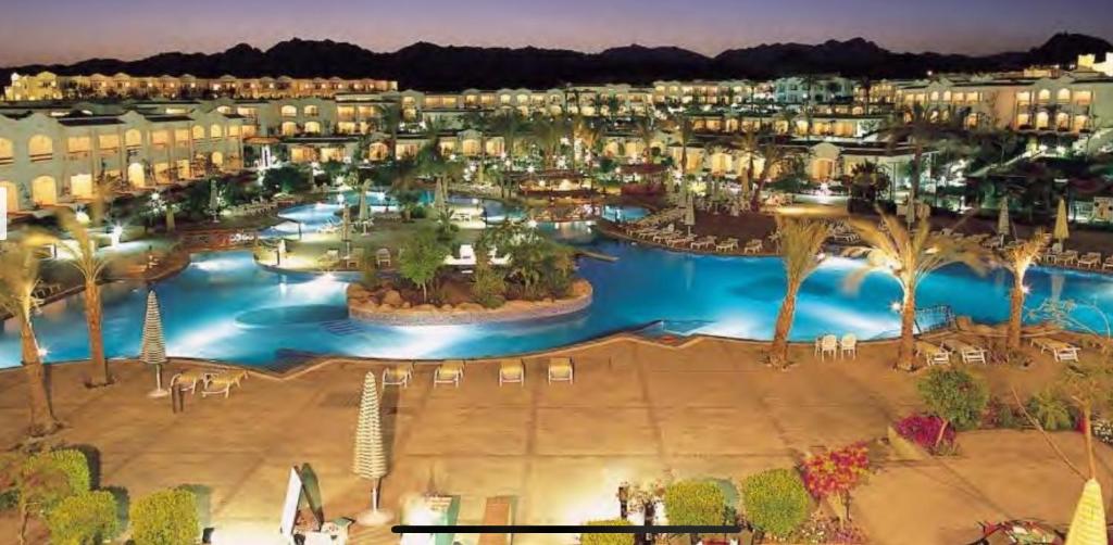 Private Luxury Villas at Sharm Dreams Resort في شرم الشيخ: اطلالة جوية على منتجع في الليل
