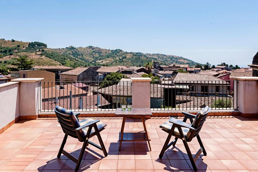 patio z dwoma krzesłami i pomnikiem na dachu w obiekcie Gli Iris Apartments by Wonderful Italy w mieście Linguaglossa