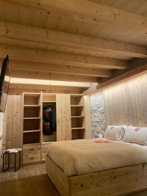 a bedroom with a large bed and wooden walls at Il Falco Affittacamere in Gallio