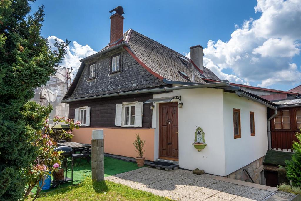 ein kleines weißes Haus mit einem Dach in der Unterkunft Chalupa u kostela in Chřibská