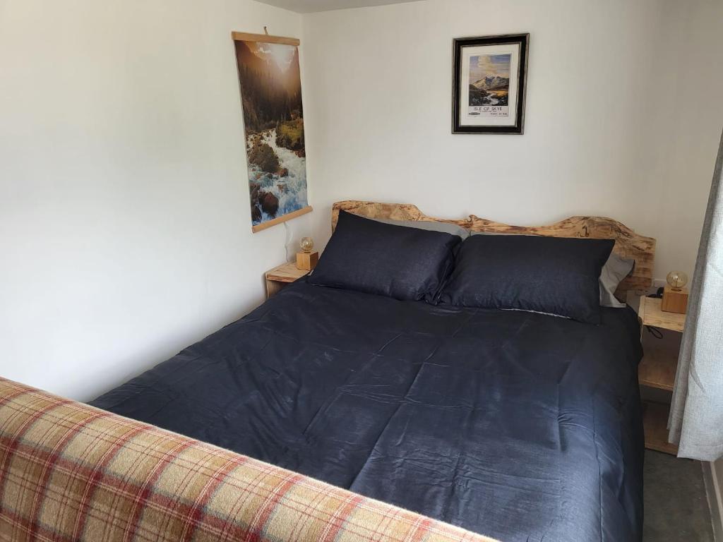 a bedroom with a bed with a blue comforter at Wee Shot in Tain