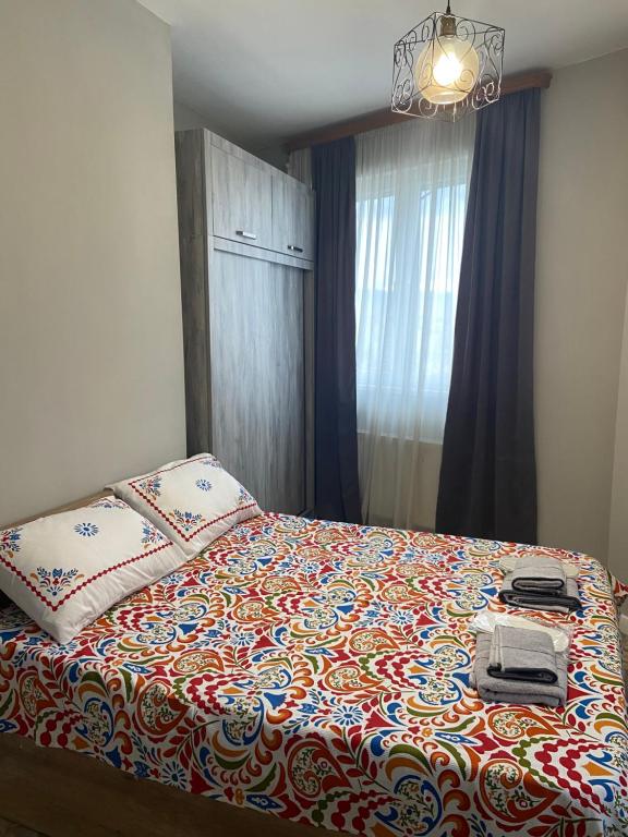 1 dormitorio con 1 cama con colcha colorida en Apartments on Bakradze en Tiflis