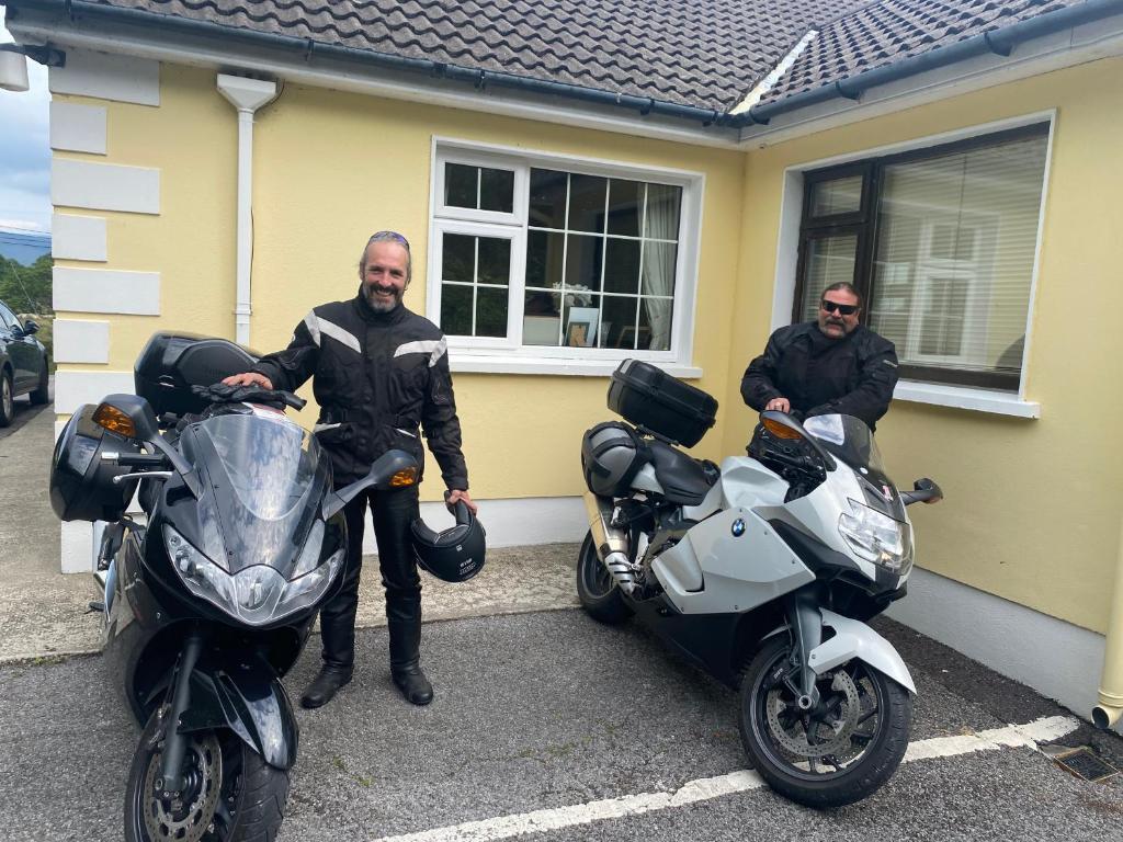 two men are standing next to their motorcycles at Oakfield in Kenmare