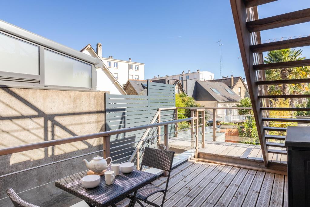 un patio avec une table et des chaises sur un balcon dans l'établissement YOKOSO - Studio proche CHU avec terrasse, à Rennes