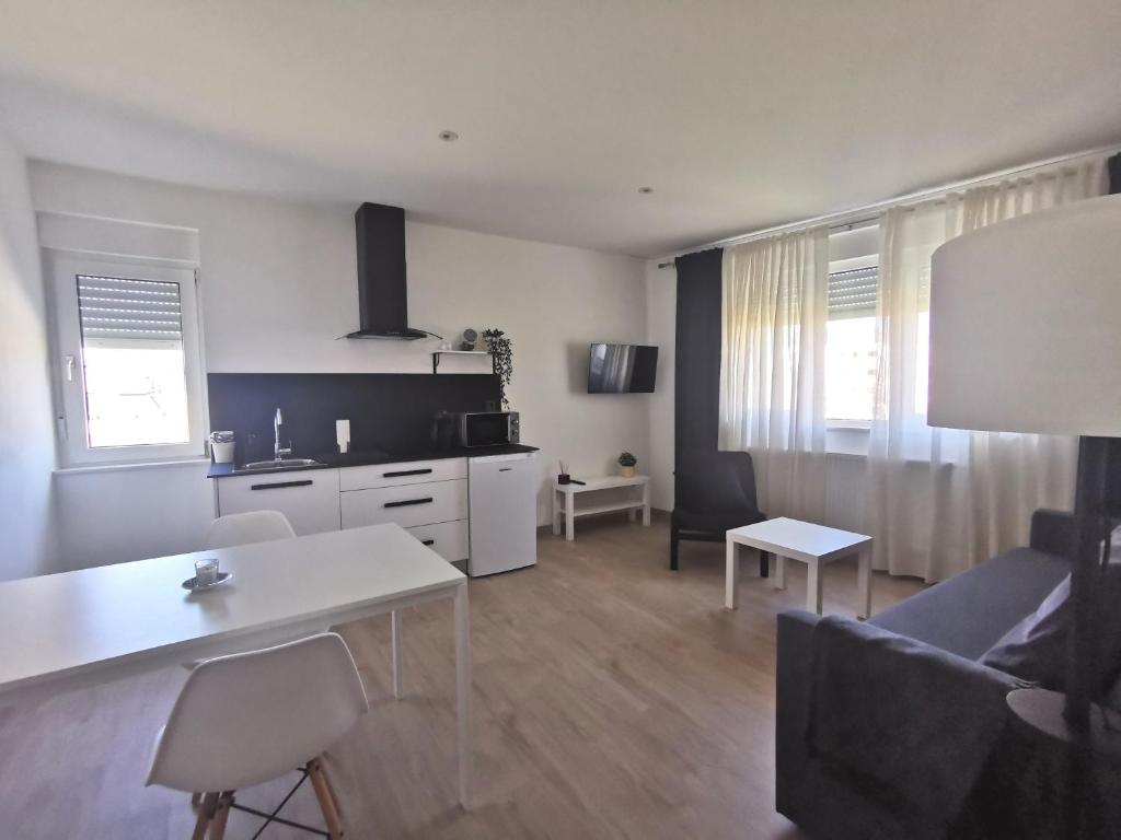 cocina y sala de estar con sofá y mesa en Apartamentos Seijo, en Vilalba