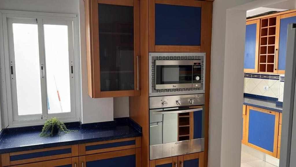 a kitchen with a stove and a microwave at Apartamento Kalma 1 in Corralejo