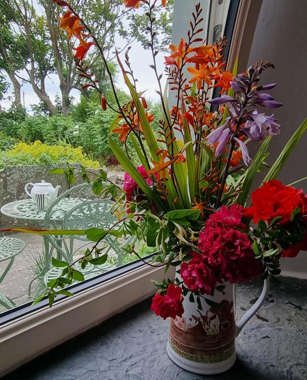 a vase filled with flowers sitting in a window at Bay View House in Liscannor