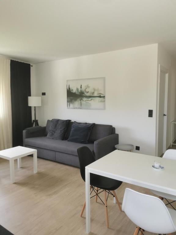a living room with a couch and a table at Apartamentos Seijo in Villalba