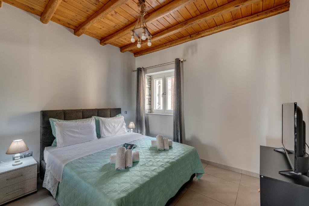 a bedroom with a large bed with a television at TAKIS GUESTHOUSE-Orneda-HERMOUPOLIS in Ermoupoli
