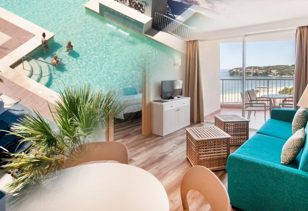 sala de estar con piscina y sofá azul en Apartamentos Vistasol en Magaluf