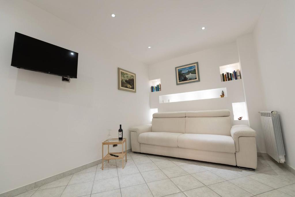 a living room with a white couch and a flat screen tv at Casa Elia: Locazione Breve in Noto