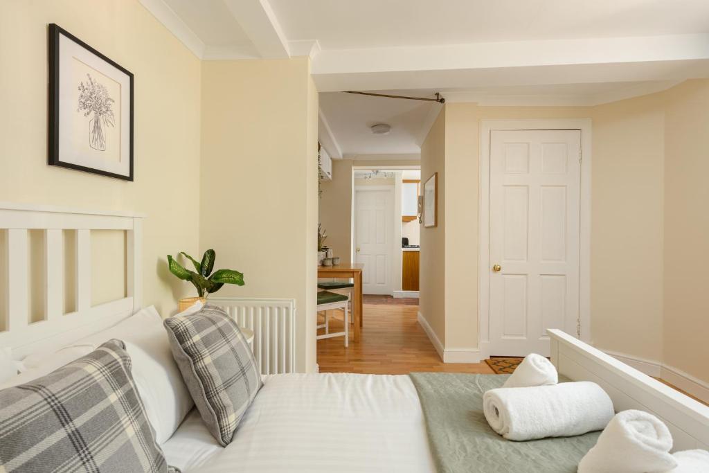 a bedroom with a white bed and a hallway at Cosy Dean Village Studio in Edinburgh
