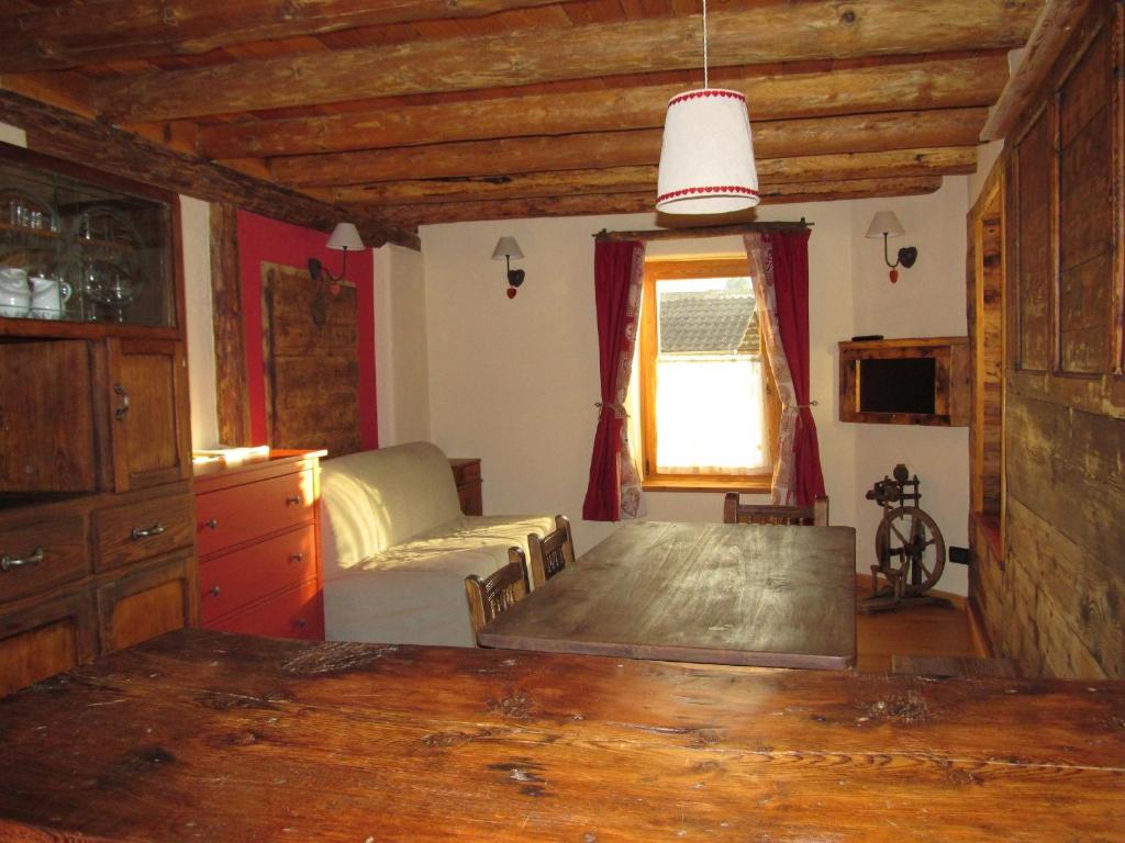 een woonkamer met een tafel en een bank bij Alloggio Gran Paradiso in Aosta