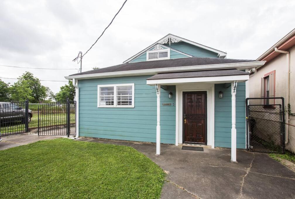 a blue house with a door in a yard at Big Easy Charmer License #23-OSTR-12410 in New Orleans