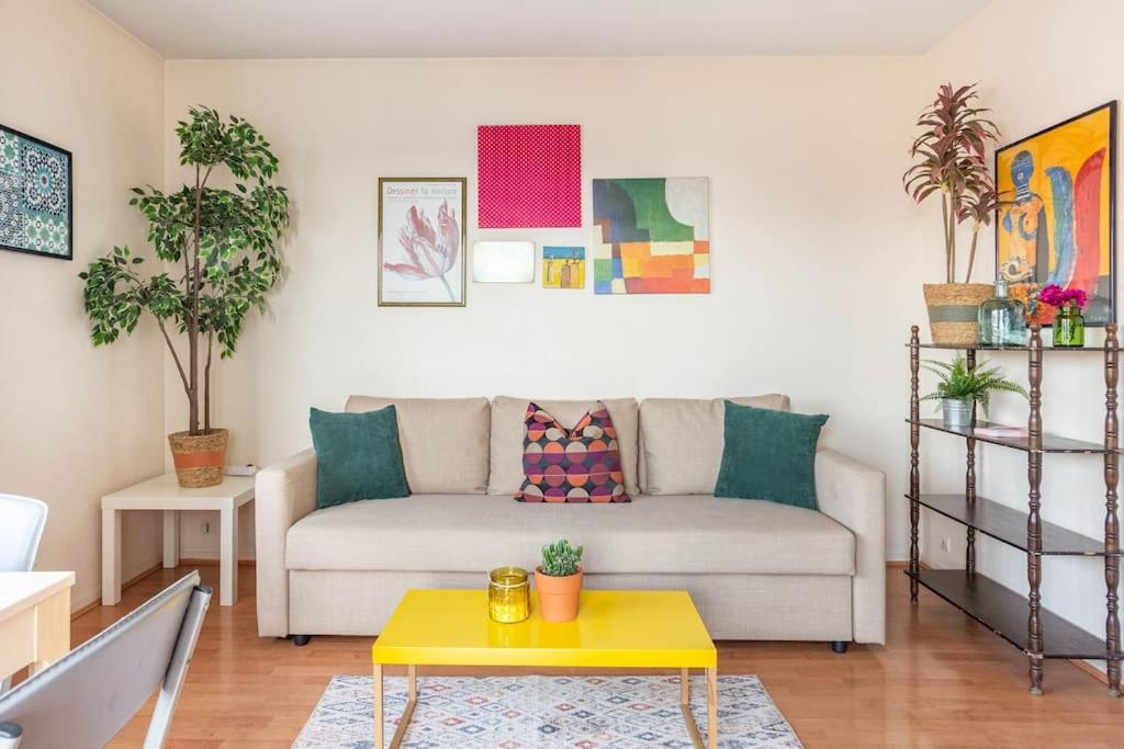sala de estar con sofá y mesa amarilla en Appartement à 10 minutes du centre de Paris avec le RER B, en La Courneuve