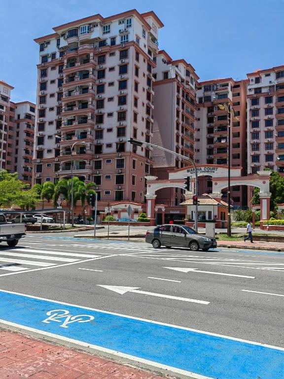 een auto die rijdt op een stadsstraat met hoge gebouwen bij Marina Court Kota Kinabalu in Kota Kinabalu